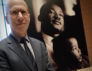 Image of author Jonathan Eig with a portrait of Doctor Martin Luther King Junior in the background