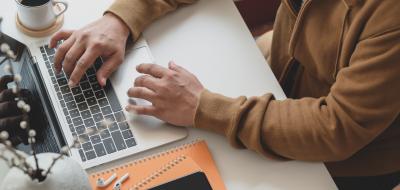 Person in brown long sleeve sweater using macbook pro