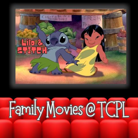 Movie screen with image of a little girl and a cute blue alien dancing. There are red seats in the foreground of the image.