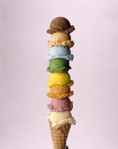 An ice cream cone stacked with eight different flavors in multiple colors